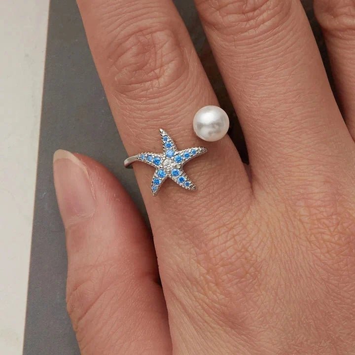 Starfish ring with blue stones and pearl, worn on hand